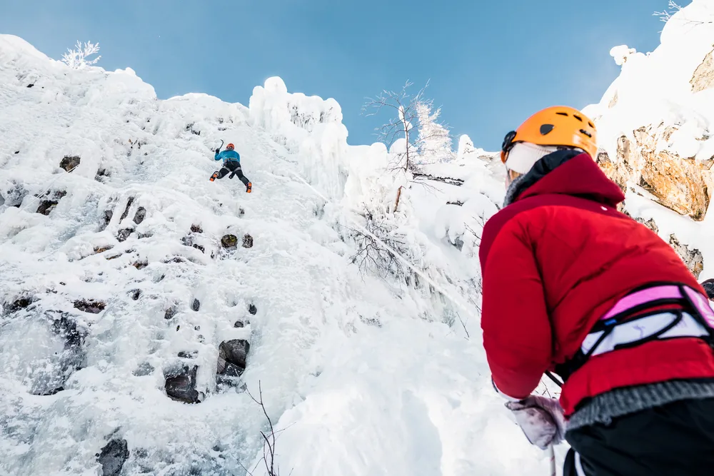 Two helmeted climbers on an ice wall in Pyhä